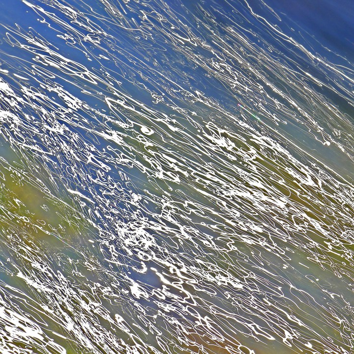 Autumn sun draws lines across the limestone, the water reflecting blue sky and pulling earth shades from the rcok below